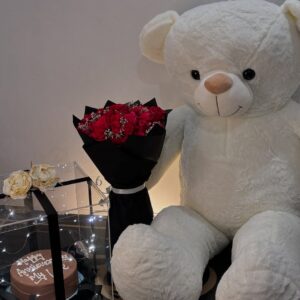 Teddy bear with flowers and chocolate cake for birthday surprise